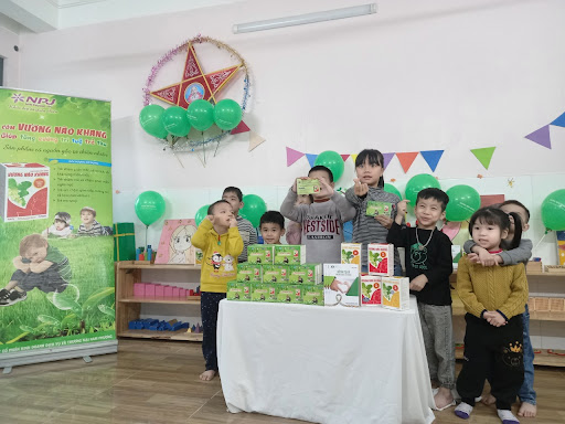 Hình ảnh các bé vui vẻ nhận quà tặng của nhãn hàng Vương Não Khang
